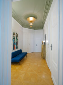 Altbausanierung in Wien: Restaurierung und Innenanstrich einer Stuckdecke im Flur mit modernem Farbkonzept.